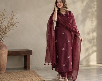 May include: A deep maroon three-piece ensemble consisting of a long-sleeved straight-cut tunic, matching trousers, and a sheer dupatta. The tunic features a V-neckline and delicate white floral embroidery scattered across the fabric.