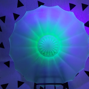 May include: A white, fluted glass bowl with a green centre. The bowl is illuminated with a blue and purple light, creating a vibrant effect.