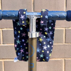 K&ouml;nnte beinhalten: Blaue Rollerlenker mit schwarzen Stofflenkerbez&uuml;gen mit einem wei&szlig;en Sternenmuster.