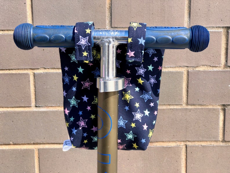 K&ouml;nnte beinhalten: Blaue Rollerlenker mit schwarzen Stofflenkerbez&uuml;gen mit einem wei&szlig;en Sternenmuster.