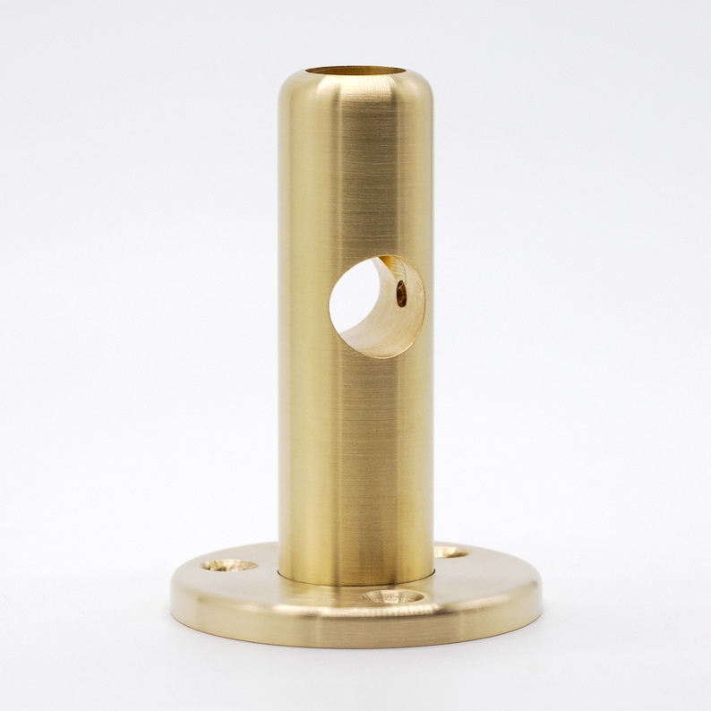May include: A gold metal pipe fitting with a round base and a hole in the center. The pipe fitting is designed to be used for connecting pipes or other plumbing fixtures.