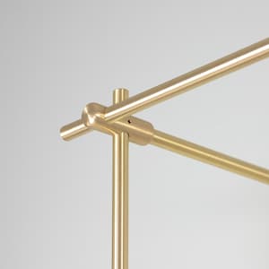 May include: Close-up of a gold metal connector for a clothing rack. The connector is made of two pieces that fit together to create a sturdy and stylish connection.