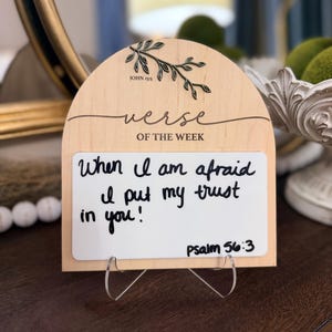 May include: Wooden "Verse of the Week" sign with a white writing surface. The sign features the text "When I am afraid I put my trust in you!" and "Psalm 56:3". The top of the sign has the text "John 15:5" and a decorative branch.