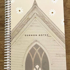 Puede incluir: Una libreta de espiral beige con un edificio de iglesia blanco en la portada. La iglesia tiene una gran ventana arqueada y el texto "SERMON NOTES" está impreso en la parte delantera. El fondo es beige claro con margaritas blancas.