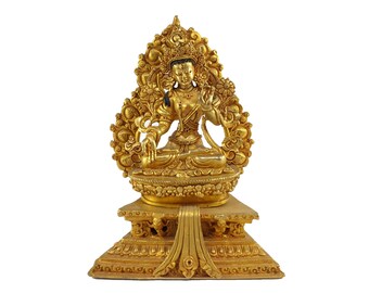 May include: A gold-coloured statue of a deity sitting in a lotus position. The statue is adorned with intricate details and is placed on a pedestal.