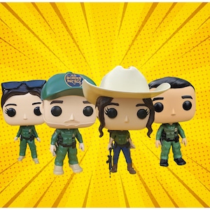 May include: Four Funko Pop figures depicting U.S. Border Patrol agents. Each figure is dressed in a green uniform. One figure holds a rifle, another wears a cowboy hat, and one wears a green cap with the words "U.S. Border Patrol".