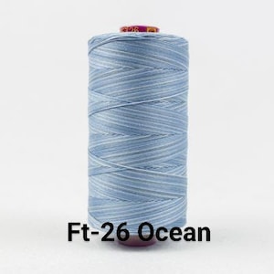 May include: A spool of light blue thread with white stripes. The spool is labeled "Ft-26 Ocean".