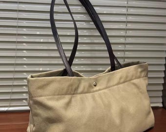 Mochila leve e de grande capacidade para uso diário, feita em lona ecológica com alça de ombro em couro.