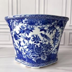 May include: A white ceramic mug with a black handle and the text "But First, Coffee" in a handwritten style. The mug is on a white surface. The mug is 4 inches tall.