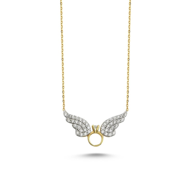 Pu&ograve; includere: Una collana d'oro con un ciondolo a forma di ala d'angelo tempestato di diamanti e con un anello al centro.