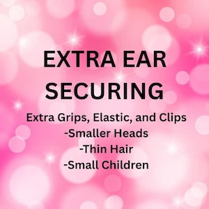 May include: Pink background with white bokeh and text that reads "EXTRA EAR SECURING." Additional text states "Extra Grips, Elastic, and Clips" and lists "Smaller Heads, Thin Hair, Small Children."