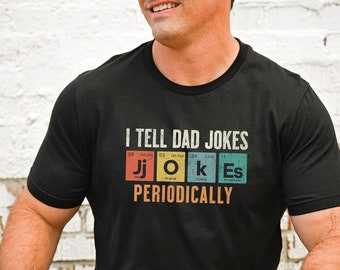 May include: Black t-shirt with a graphic of the periodic table elements spelling out "I TELL DAD JOKES PERIODICALLY".