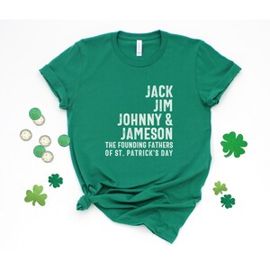 May include: Green t-shirt with white text that reads "Jack Jim Johnny & Jameson The Founding Fathers of St. Patrick's Day"