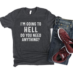 Puede incluir: Una camiseta gris oscuro con el texto "I'm going to hell do you need anything?" impreso en blanco.