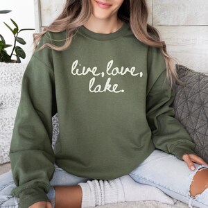 May include: A green sweatshirt with the text "live, love, lake." printed in white.