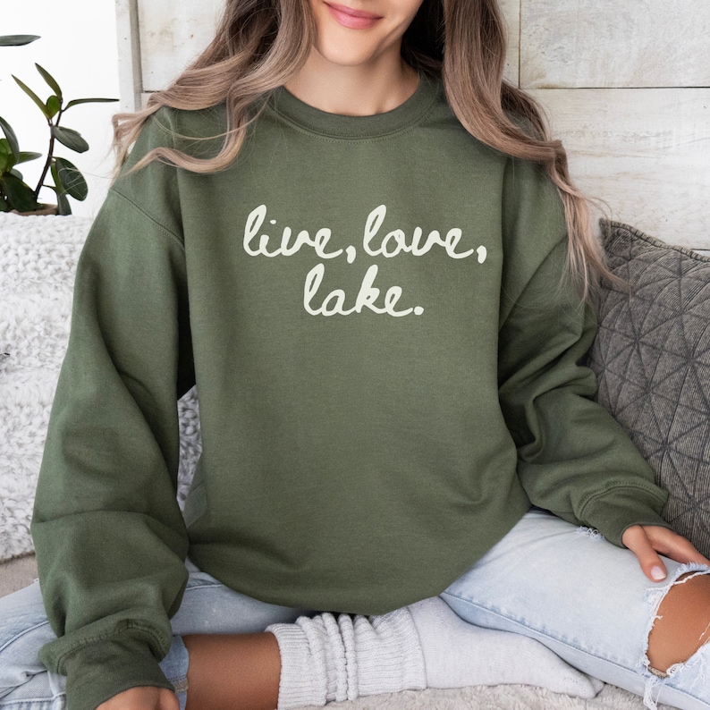 May include: A green sweatshirt with the text "live, love, lake." printed in white.