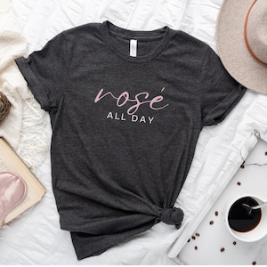 May include: A dark gray t-shirt with the text "ros&eacute; all day" in pink lettering.