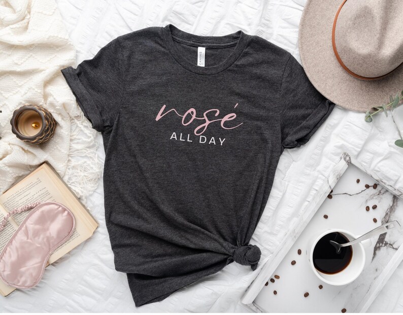 May include: A dark gray t-shirt with the text "ros&eacute; all day" in pink lettering.