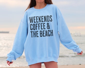 May include: A light blue sweatshirt with the text "Weekends Coffee & The Beach" printed in black.