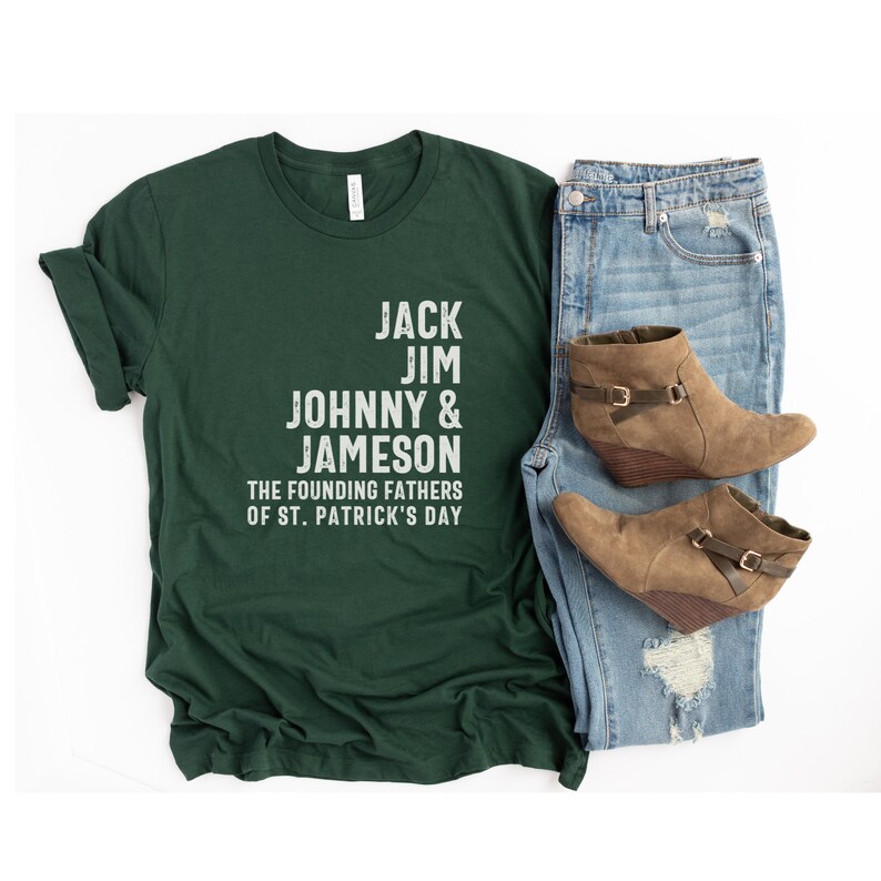 May include: A dark green t-shirt with white text that reads "Jack Jim Johnny & Jameson The Founding Fathers of St. Patrick's Day".