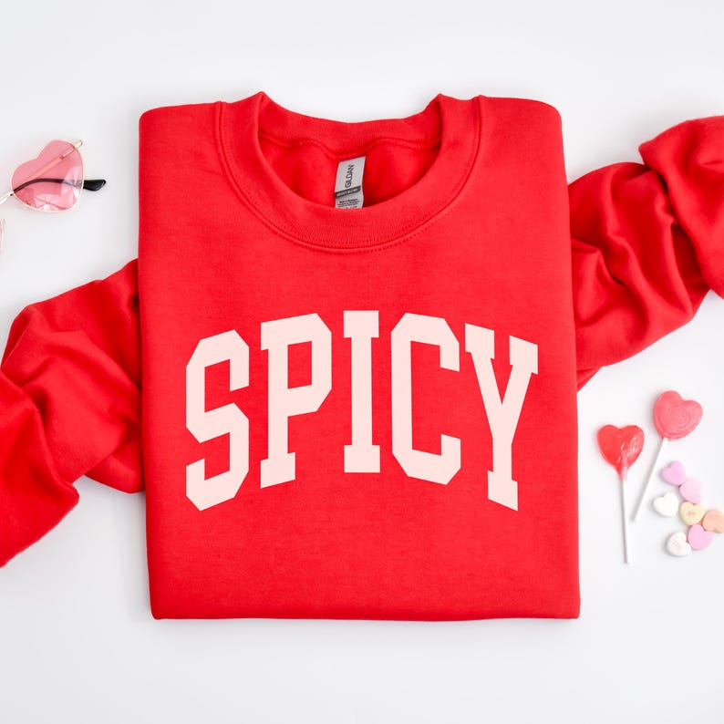 K&ouml;nnte beinhalten: Roter Pullover mit dem Wort "SPICY" in Wei&szlig; auf der Vorderseite.