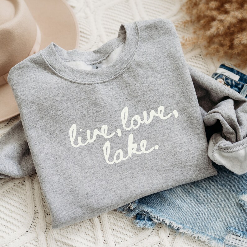May include: Gray sweatshirt with the text "live, love, lake." in white script.