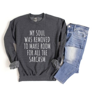 Może przedstawiać: Szara bluza z nadrukiem "My soul was removed to make room for all the sarcasm" w kolorze białym.