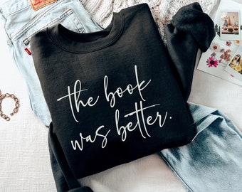Puede incluir: Sudadera negra con el texto "The book was better." en letras blancas.