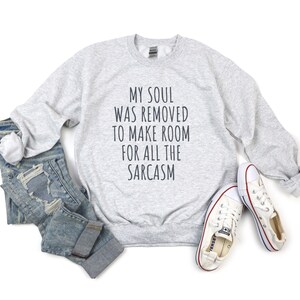 Może przedstawiać: Szara bluza z nadrukiem "My soul was removed to make room for all the sarcasm" na przodzie.