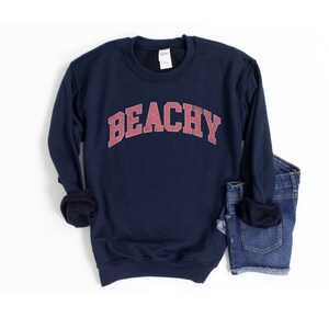 May include: Navy blue sweatshirt with a red "Beachy" graphic in a collegiate font.
