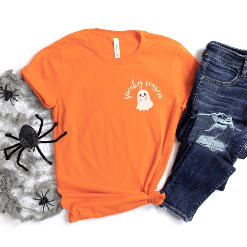 May include: Orange t-shirt with a white ghost graphic and the text "spooky season".
