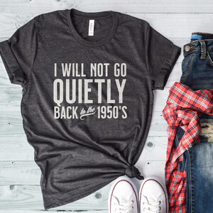 May include: A dark gray t-shirt with the text "I will not go quietly back to the 1950's" printed in white.