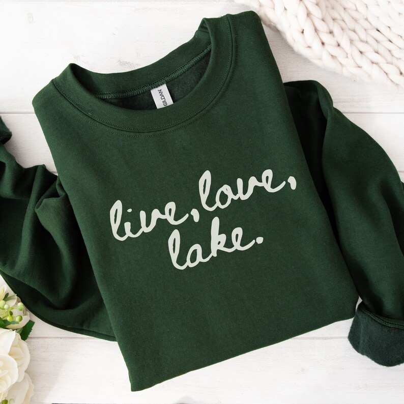 May include: A dark green sweatshirt with the text "live, love, lake." printed in white.