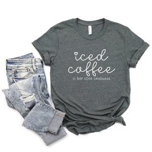 Puede incluir: Una camiseta gris oscuro con el texto "iced coffee is my love language" en letras blancas.