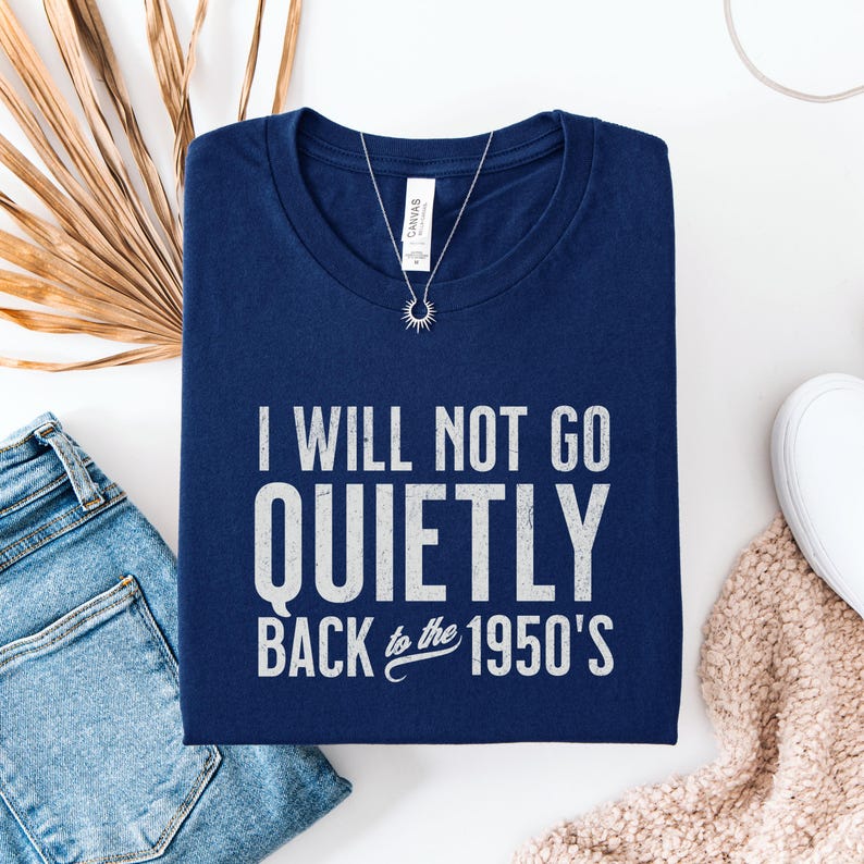May include: A navy blue t-shirt with white text that reads "I will not go quietly back to the 1950's".