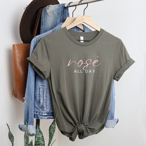 May include: A green t-shirt with the text "ros&eacute; all day" in pink lettering.
