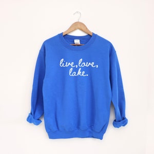 May include: Royal blue sweatshirt with the text "live, love, lake." in white cursive lettering.