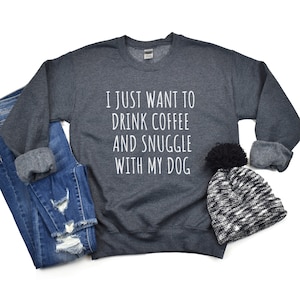 May include: A dark grey sweatshirt with the text "I just want to drink coffee and snuggle with my dog" printed in white.