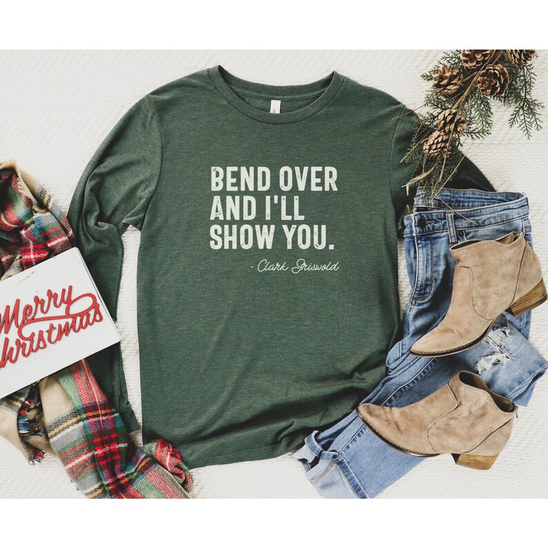 May include: A green long-sleeved t-shirt with the text "Bend over and I'll show you." - Clark Griswold.