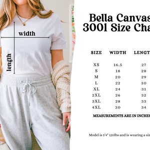 Puede incluir: Tabla de tallas Bella Canvas 3001 que muestra las medidas de ancho y largo en pulgadas para las tallas XS a 4XL. La tabla incluye el texto "Measurements are in inches".