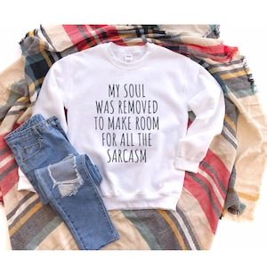 Może przedstawiać: Biała bluza z nadrukiem "My soul was removed to make room for all the sarcasm" na przodzie.