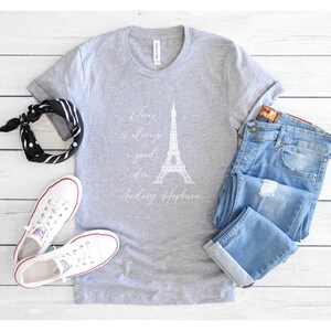K&ouml;nnte beinhalten: Ein graues T-Shirt mit einem wei&szlig;en Aufdruck des Eiffelturms und dem Zitat "Paris ist immer eine gute Idee - Audrey Hepburn".