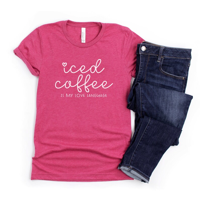 Puede incluir: Una camiseta rosa con el texto "iced coffee is my love language" en letras blancas en cursiva.
