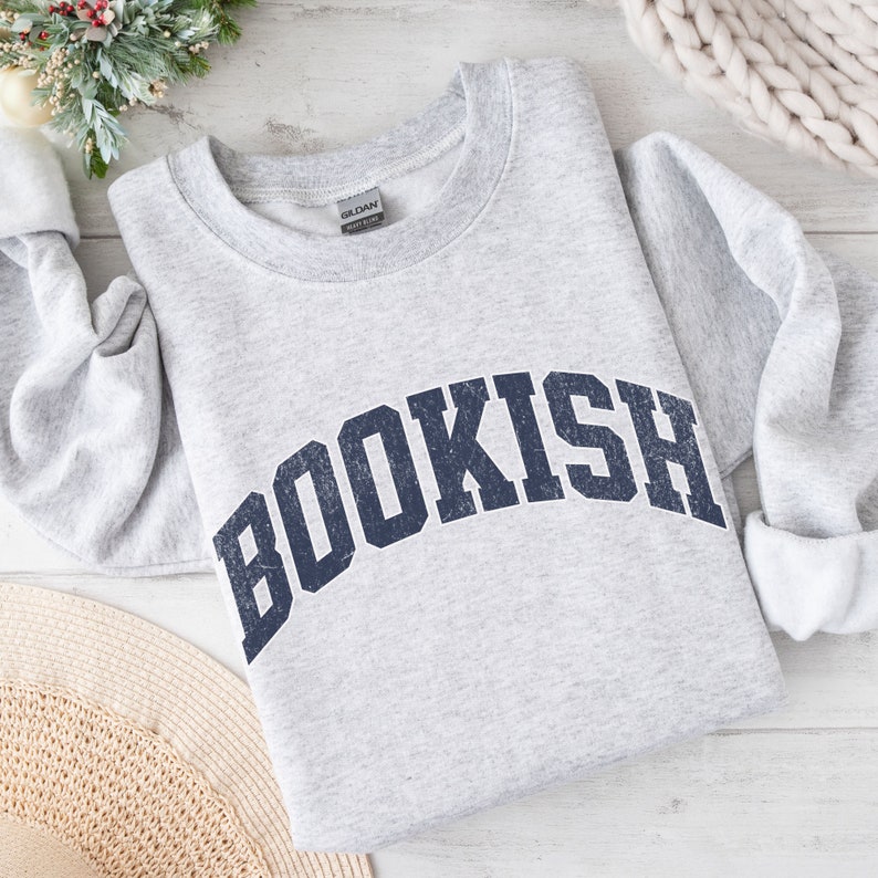 May include: Gray sweatshirt with a navy blue "BOOKISH" graphic in a collegiate font style.