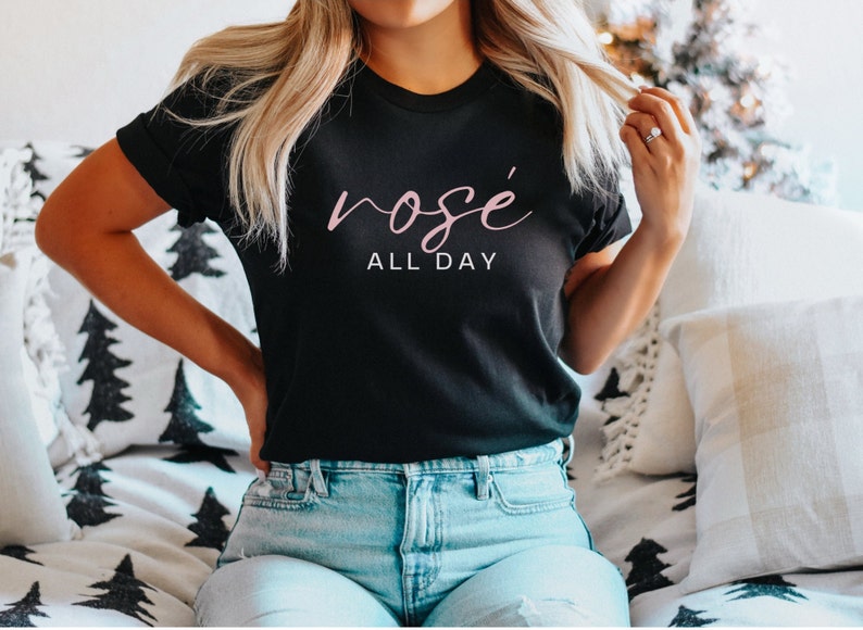May include: A black t-shirt with the text "ros&eacute; all day" in pink lettering.