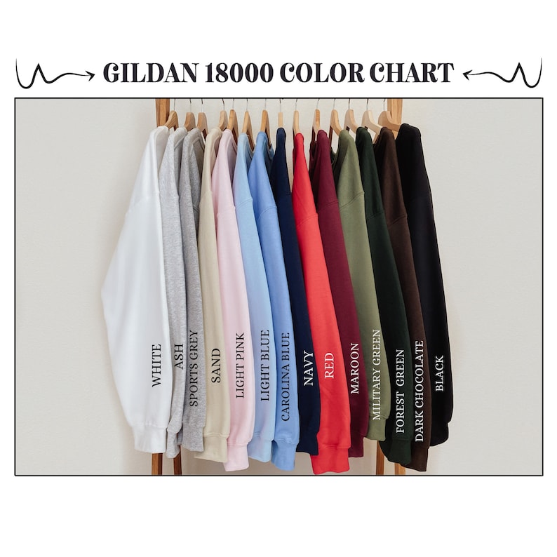 May include: Color chart for Gildan 18000 sweatshirts, showing 14 different colors: white, ash, sports grey, sand, light pink, light blue, Carolina blue, navy, red, maroon, military green, forest green, dark chocolate, and black.