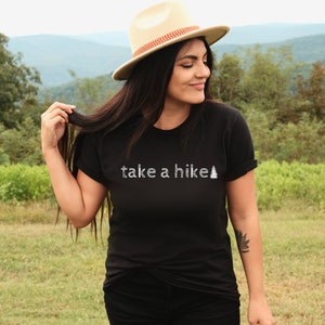 May include: A black t-shirt with the text "take a hike" and a small pine tree graphic in white.
