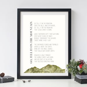 May include: A printable Christmas carol poster with a watercolor illustration of green mountains. The text reads "Go, Tell It On The Mountain, Go Tell It On The Mountain, Over The Hills, And Everywhere, Go, Tell It On The Mountain That Jesus Christ Is Born. While Shepherds Kept Their Watching O'er Silent Flocks By Night, Behold, Throughout The Heavens There Shone A Holy Light. The Shepherds Feared And Trembled When Lo, Above The Earth Rang Out The Angel Chorus That Hailed Our Savior's Birth Down In A Lowly Manger The Humble Christ Was Born, And God Sent Us Salvation That Blessed Christmas Morn"