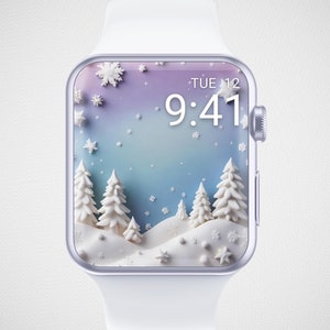 May include: A white smartwatch with a winter-themed display. The screen shows a snowy landscape with white trees, snowflakes, and the time, 9:41, on Tuesday the 12th. The watch has a white band and a silver-colored frame.