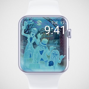 Peut inclure: Une Apple Watch blanche avec un cadran de montre numérique bleu et blanc représentant une maison hantée et trois fantômes. Il est 9h41. Le cadran de la montre indique "TUE 12".